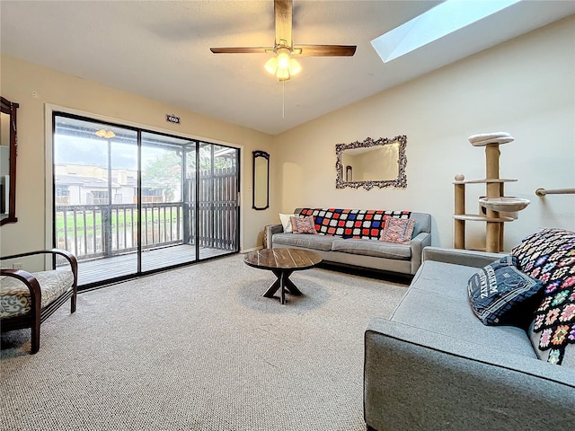 carpeted living room featuring a skylight, ceiling fan, and vaulted ceiling