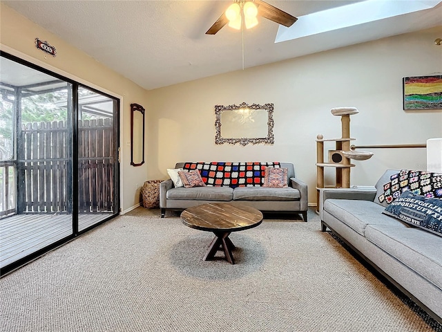 carpeted living room featuring ceiling fan, a skylight, and baseboards