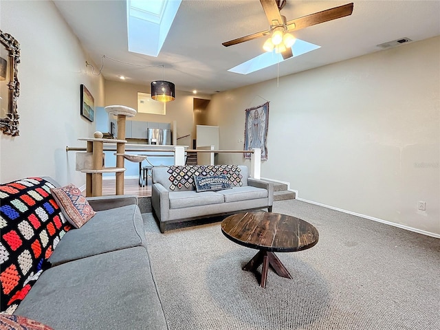 carpeted living area featuring a skylight, baseboards, and a ceiling fan