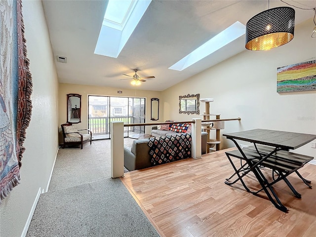 bedroom featuring a skylight, vaulted ceiling, baseboards, and wood finished floors