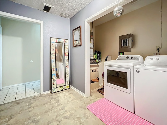 washroom with independent washer and dryer, electric panel, a textured ceiling, and tile patterned flooring