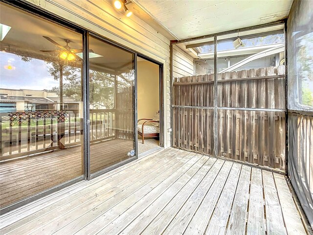 unfurnished sunroom with ceiling fan