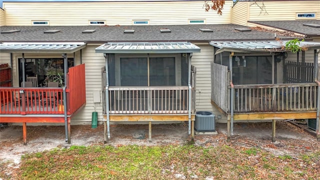 back of house with cooling unit and roof with shingles