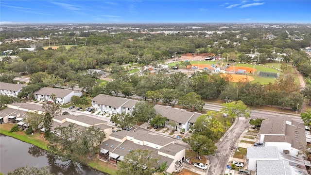 aerial view of property and surrounding area with a large body of water and nearby suburban area