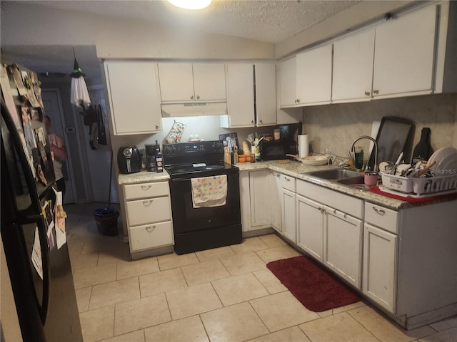 kitchen with white cabinets, sink, black electric range, light tile patterned floors, and a textured ceiling