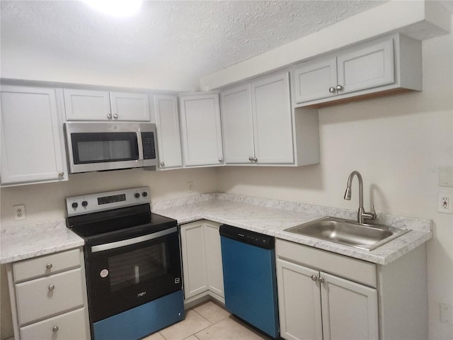 11608 Zimmerman Rd, Port Richey, FL 34668 - kitchen with stainless steel appliances, a sink, a textured ceiling, light countertops, and light tile patterned floors