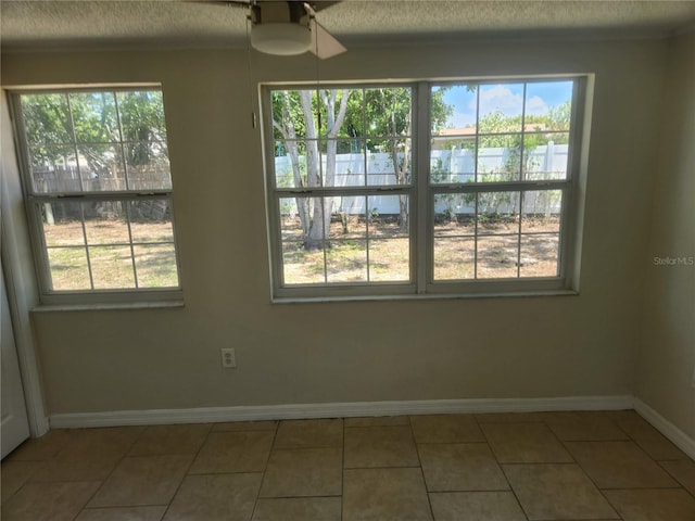 11608 Zimmerman Rd, Port Richey, FL 34668 - tiled empty room featuring a water view, healthy amount of natural light, baseboards, and a textured ceiling