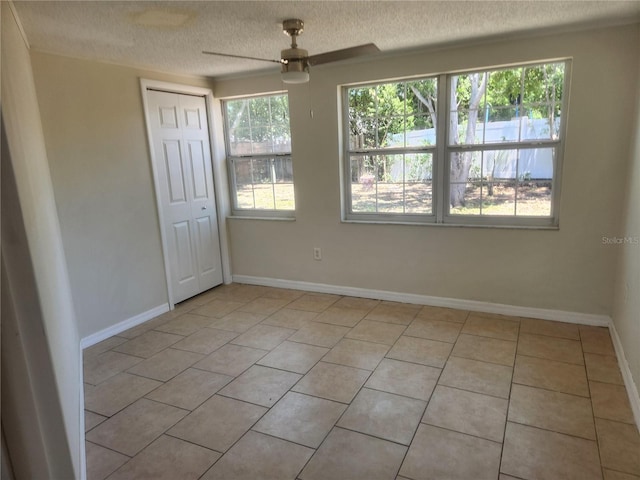11608 Zimmerman Rd, Port Richey, FL 34668 - unfurnished room featuring a textured ceiling, light tile patterned flooring, a ceiling fan, and baseboards
