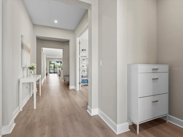 hallway with light hardwood / wood-style floors