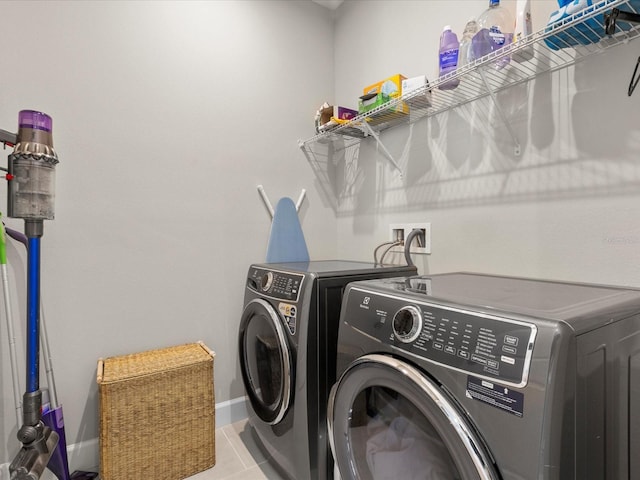 clothes washing area with light tile patterned floors and independent washer and dryer