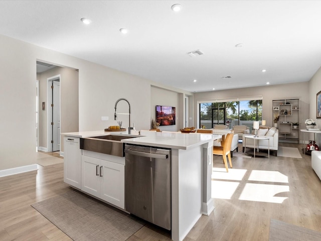 kitchen with sink, light hardwood / wood-style flooring, dishwasher, white cabinetry, and an island with sink