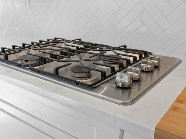 room details featuring stainless steel gas stovetop and backsplash