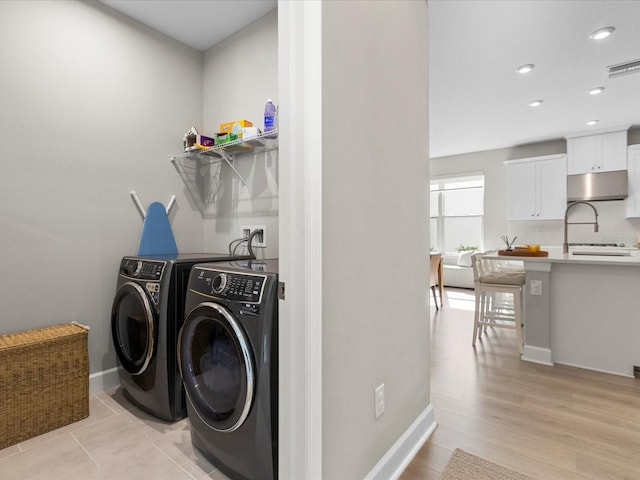 laundry room featuring light hardwood / wood-style floors and separate washer and dryer