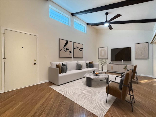 living room with beamed ceiling, ceiling fan, wood-type flooring, and high vaulted ceiling