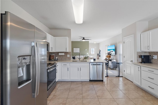 kitchen featuring tasteful backsplash, ceiling fan, white cabinets, and appliances with stainless steel finishes