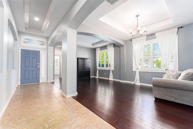 entryway featuring a tray ceiling, light hardwood / wood-style flooring, and plenty of natural light