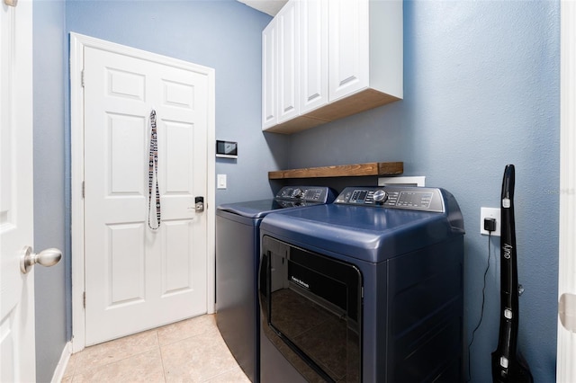 laundry area featuring cabinets, independent washer and dryer, and light tile patterned floors