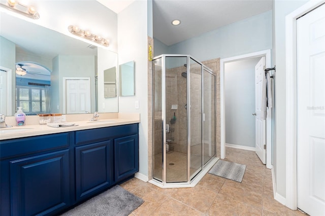 bathroom with tile patterned floors, ceiling fan, an enclosed shower, and vanity