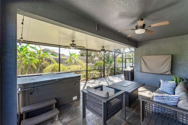 sunroom with ceiling fan and a hot tub