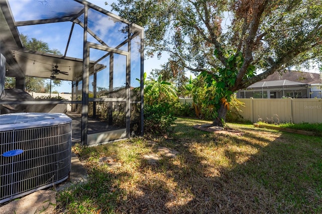 view of yard featuring ceiling fan, cooling unit, and a lanai