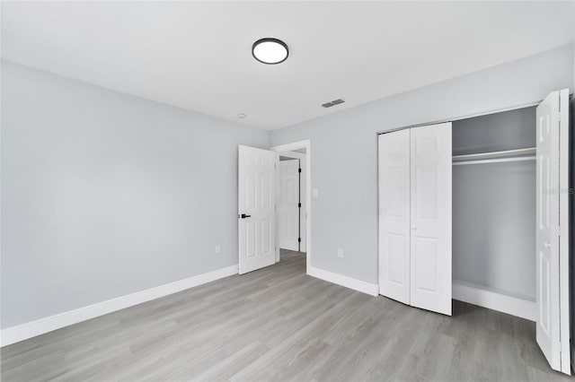 unfurnished bedroom featuring light hardwood / wood-style flooring and a closet