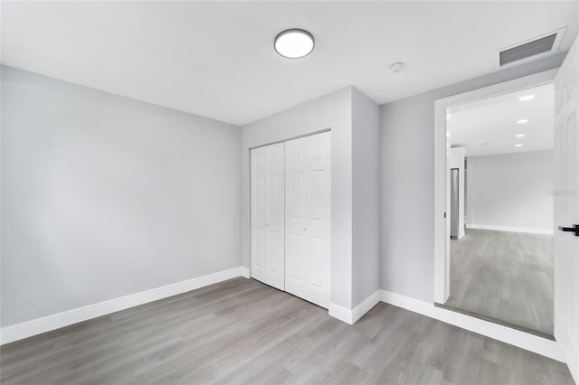 unfurnished bedroom featuring a closet and hardwood / wood-style floors