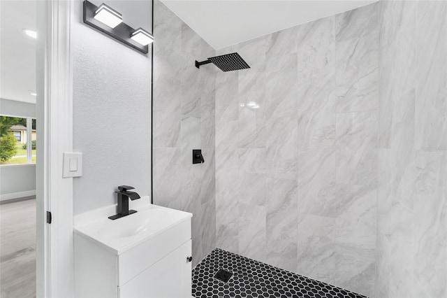 bathroom featuring a tile shower and vanity