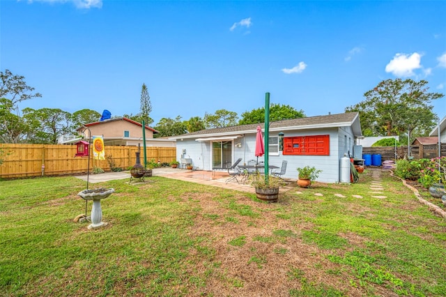 back of house with a patio area and a yard