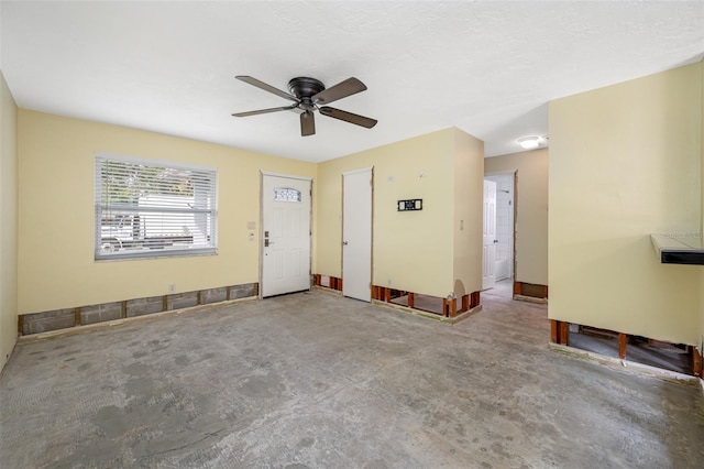 empty room with ceiling fan and concrete floors