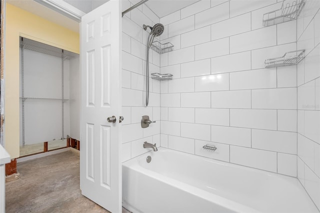 bathroom featuring concrete flooring and tiled shower / bath