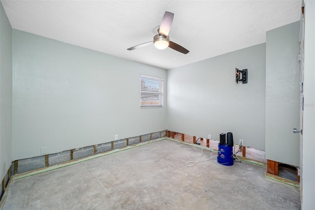 unfurnished room featuring ceiling fan and concrete floors