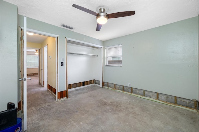 unfurnished bedroom with ceiling fan, concrete floors, and a closet