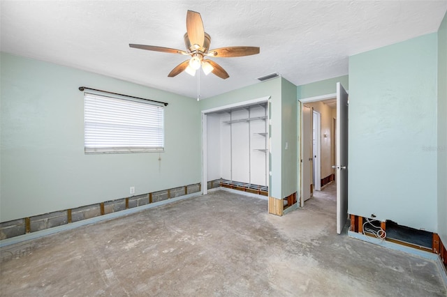 unfurnished bedroom with ceiling fan, a closet, concrete floors, and a textured ceiling