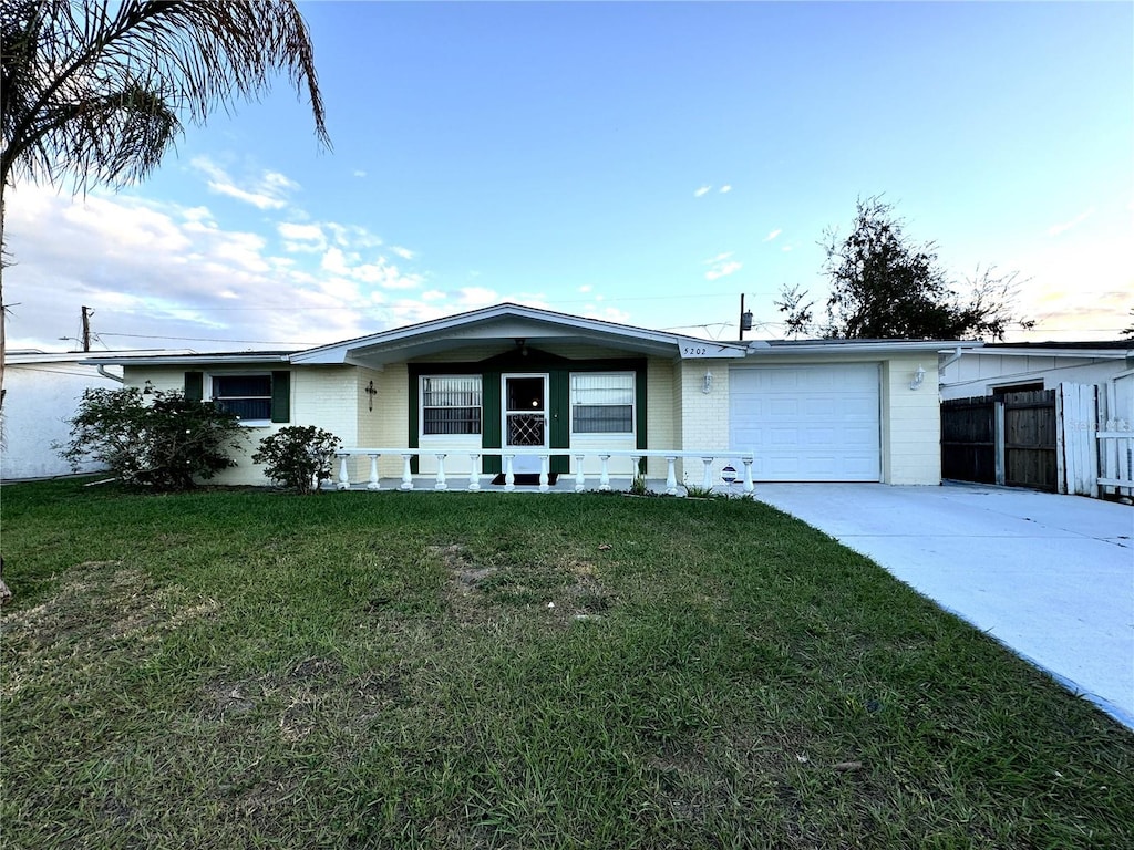 view of front of home featuring a porch, a front yard, and a garage