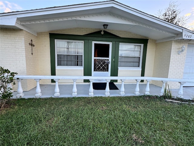 view of exterior entry with a yard