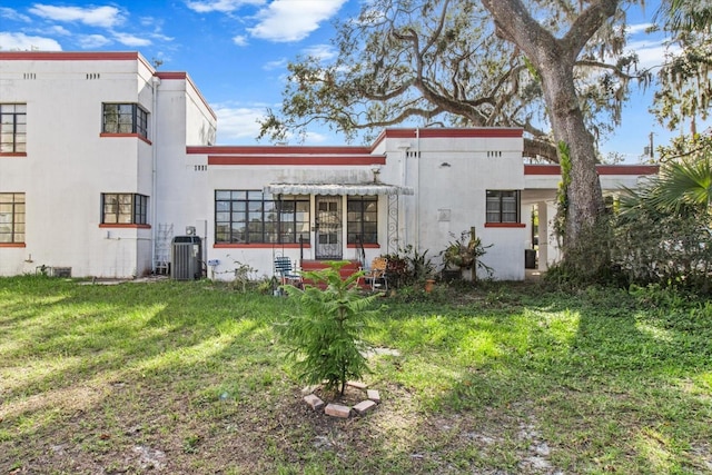 rear view of house with a yard and central AC unit