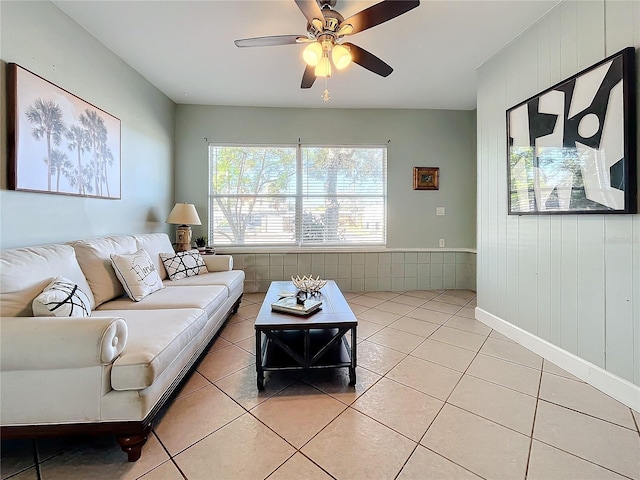 516 64th St S, Saint Petersburg, FL 33707 - living room with light tile patterned floors, a ceiling fan, wooden walls, and baseboards