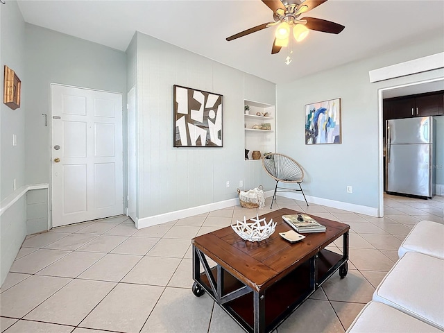 516 64th St S, Saint Petersburg, FL 33707 - living area with light tile patterned floors, baseboards, built in shelves, and a ceiling fan
