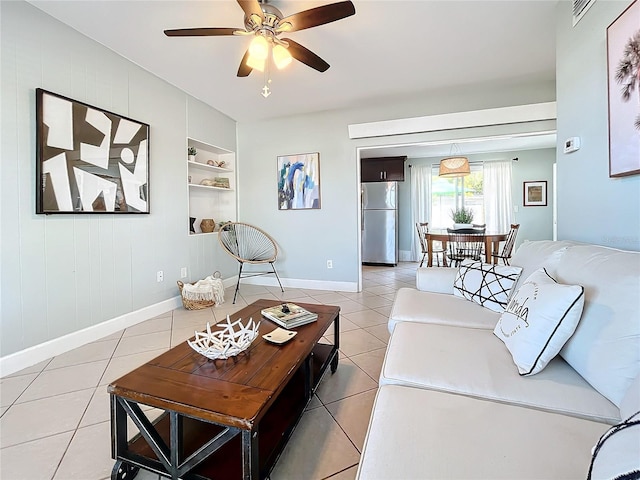 living room featuring ceiling fan, built in features, light tile patterned floors, and wood walls