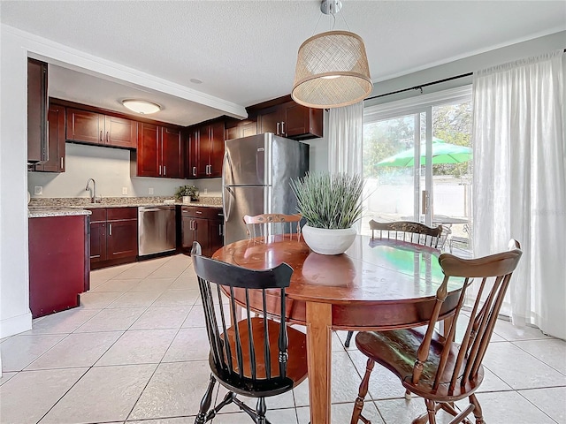 tiled dining area with sink and a textured ceiling