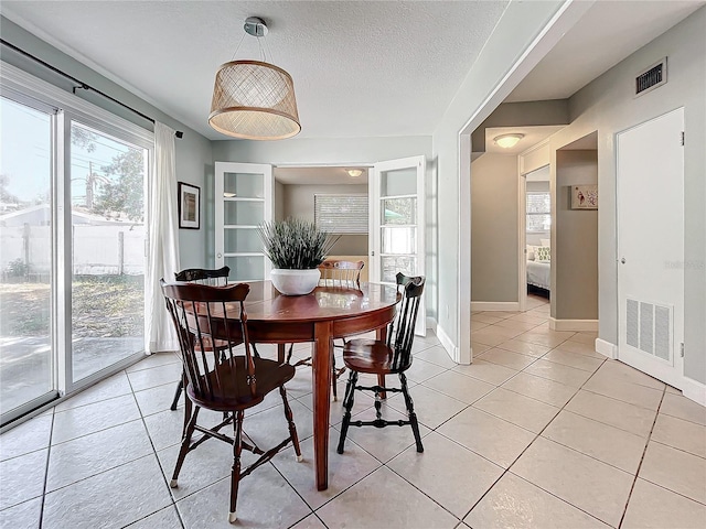 tiled dining room featuring a textured ceiling