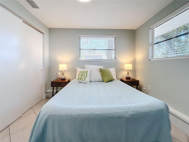 tiled bedroom featuring multiple windows