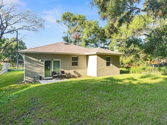 rear view of house with a lawn and a patio area