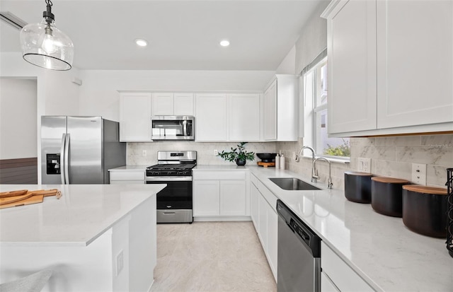 kitchen featuring pendant lighting, stainless steel appliances, white cabinetry, and sink