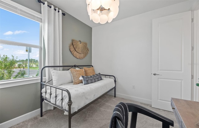 bedroom with light colored carpet and an inviting chandelier