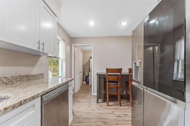 kitchen featuring dishwasher, light wood-type flooring, white cabinets, and light stone counters