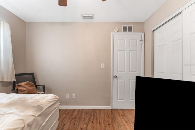 bedroom with a closet, hardwood / wood-style floors, and ceiling fan