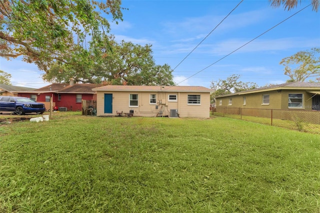 rear view of property with a lawn and cooling unit