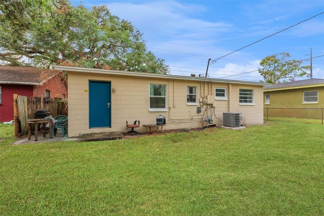 back of house featuring a yard and central AC