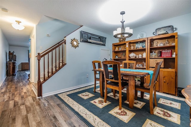 dining area with dark wood-type flooring and a chandelier